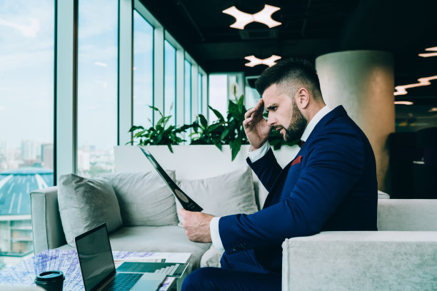 高管男性坐在办公室休息室，阅读商业报告图片下载