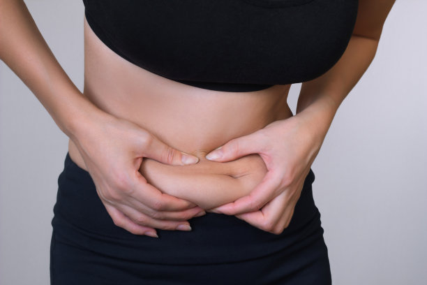 女人手握过多的腹部脂肪图片下载