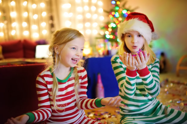 两个可爱的姐妹在家里装饰精美的房间里庆祝新年。图片下载