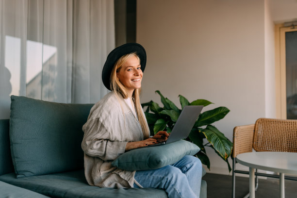 微笑的女孩为相机摆姿势，坐在舒适的图片下载