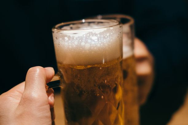 两个人用啤酒杯敬酒图片下载