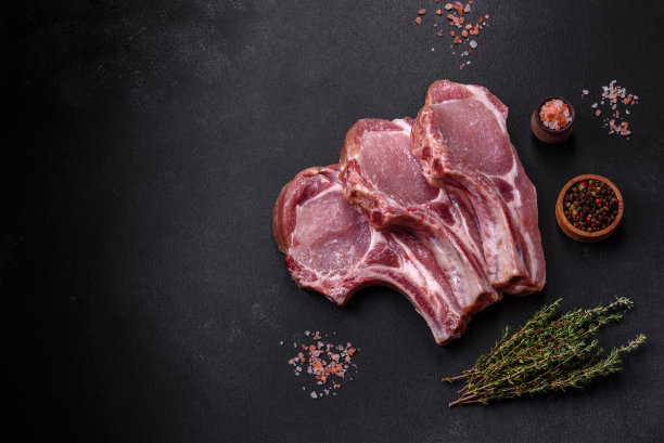 新鲜的生猪肉肋排配香料和香草放在木砧板上图片下载