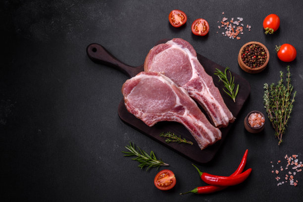 新鲜的生猪肉肋排配香料和香草放在木砧板上图片下载