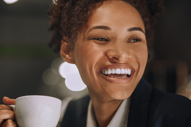 带着露齿微笑和一杯咖啡的女人图片下载