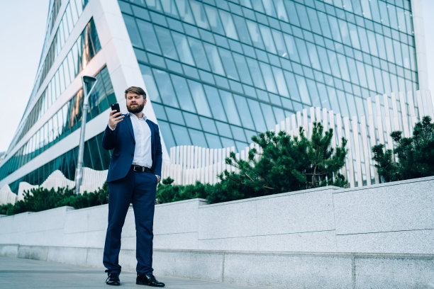 男人站在街上看手机图片下载