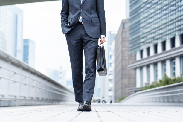 一个西装革履的男人走在商业区图片下载