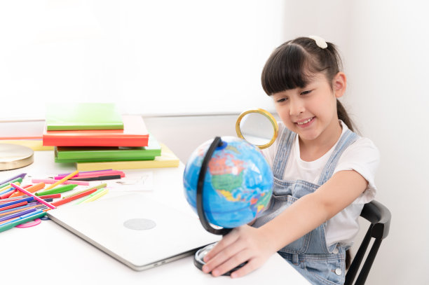 孩子女孩有趣的使用放大镜在客厅在家里图片下载