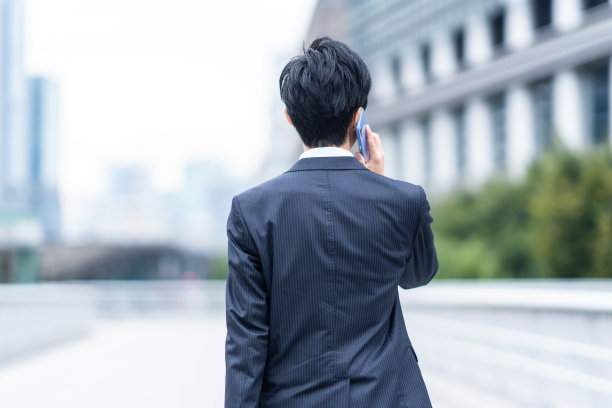 一个西装革履的男人走在商业区图片下载