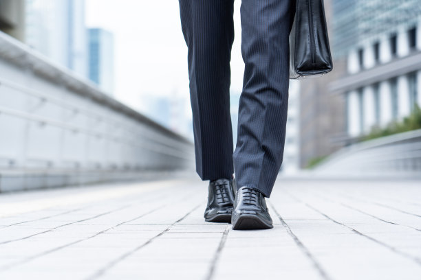 一个西装革履的男人走在商业区图片下载