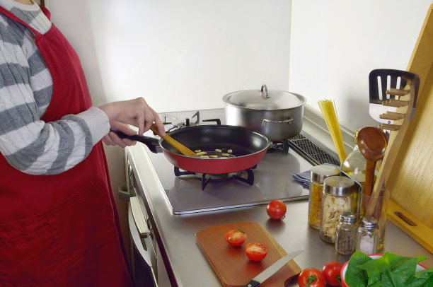 与穿红围裙的女人一起做饭的图片图片下载