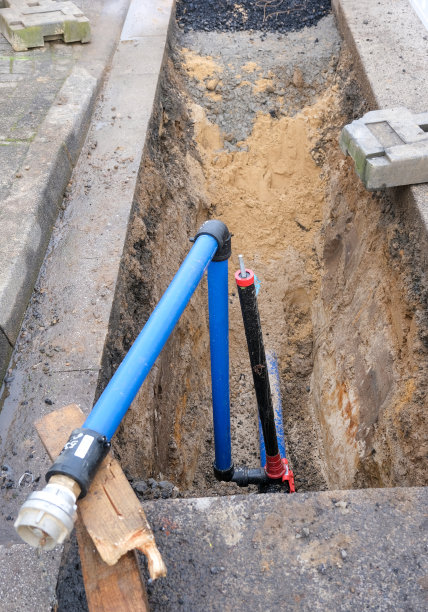 从上面看到一个开放的挖掘坑，有一个新的水连接，有一个切断阀，管道和其他供应管道图片下载