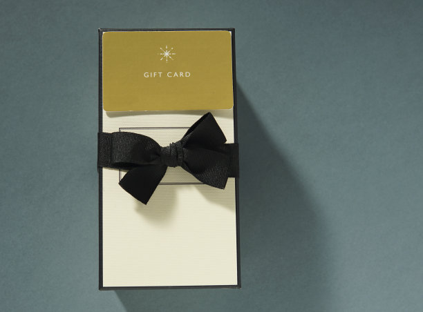 黄色礼品卡和绿色背景的礼品盒。礼品卡或礼品图片下载