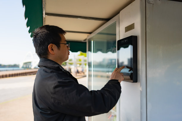一个男人在户外的自动售货机上买东西图片下载