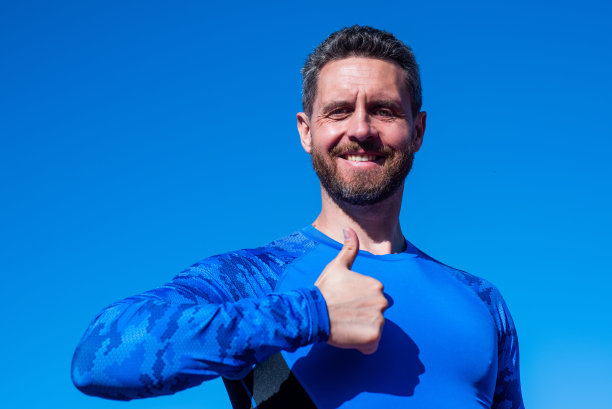 不惜一切代价取得成功。英俊的运动员竖起大拇指。球场上的自信男人。图片下载