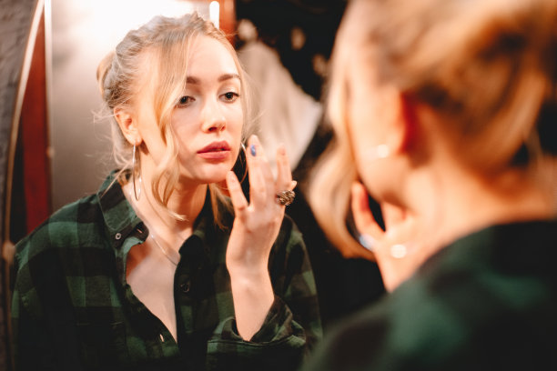 年轻女子在家里看着镜子里的自己，准备出门图片下载