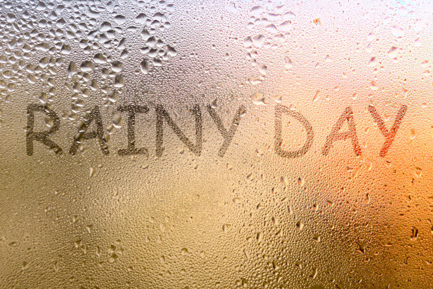 汗湿的玻璃上的铭文。雨天这个词写在玻璃上图片下载