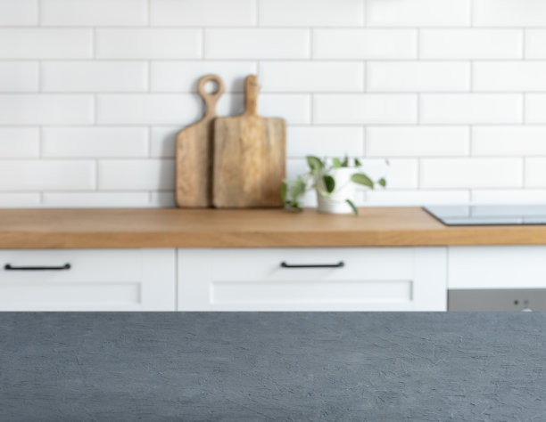 木制的蓝色台面，有自由的空间来安装产品或布局，背景是一个模糊的白色厨房，有砧板和植物。图片下载
