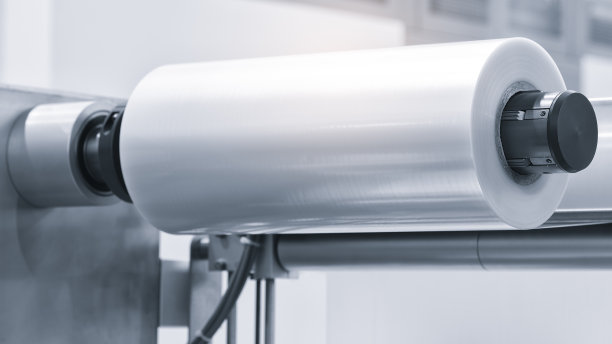 带照明效果的全自动聚乙烯塑料袋生产机。浅蓝色场景中塑料袋生产机滚筒的特写。产品包装概念图片下载