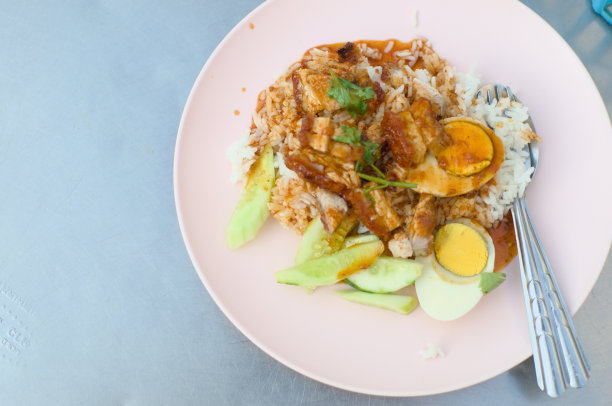 从上到下的照片，粉红色的盘子里放着泰式脆皮五花肉，放在金属桌子上炒图片下载