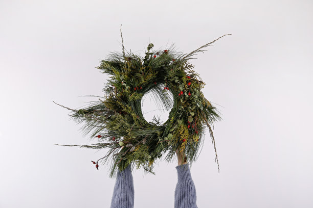 女人手中的圣诞花环。图片下载