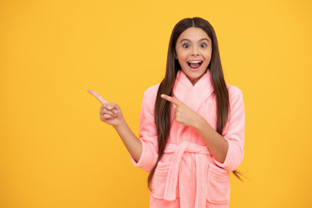 快乐的少女在家里的毛巾布浴袍指向复制空间，方向图片下载