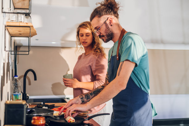 一对年轻夫妇在家里的厨房里一起做早餐图片下载