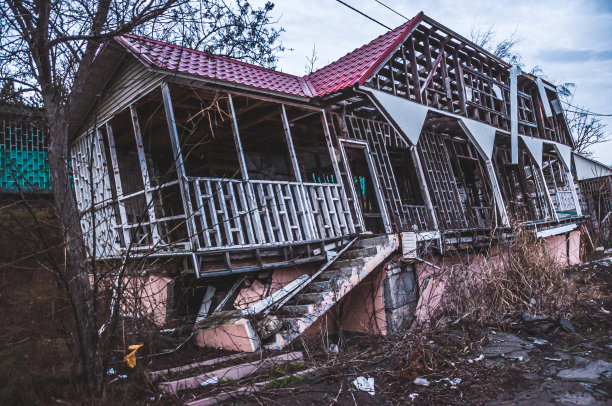 由于土质破坏，房子倾斜成一个角度。生意失败了。度假区。阴暗的废弃建筑。图片下载