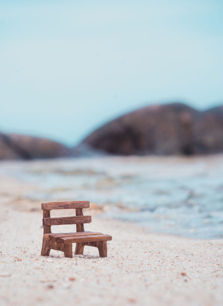 浅浅的聚焦在海边海滩上的一张木凳上图片下载