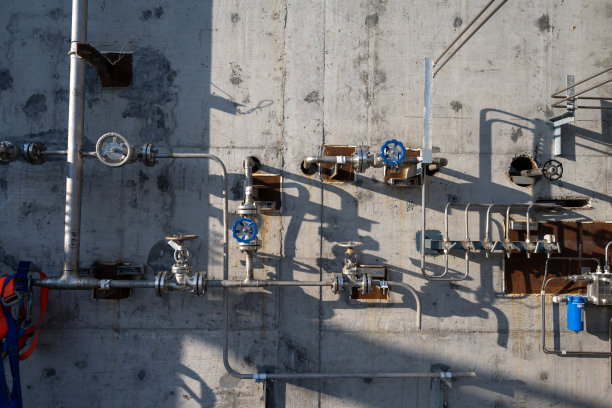 混凝土墙上的一排管道开关图片下载