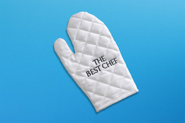 最好的厨师写在蓝色背景的白色烤箱手套上图片下载