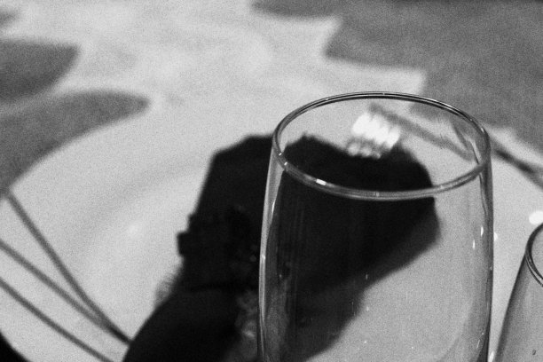 前景中装饰圣诞餐桌的酒杯。盘子和餐巾在背景中模糊图片下载