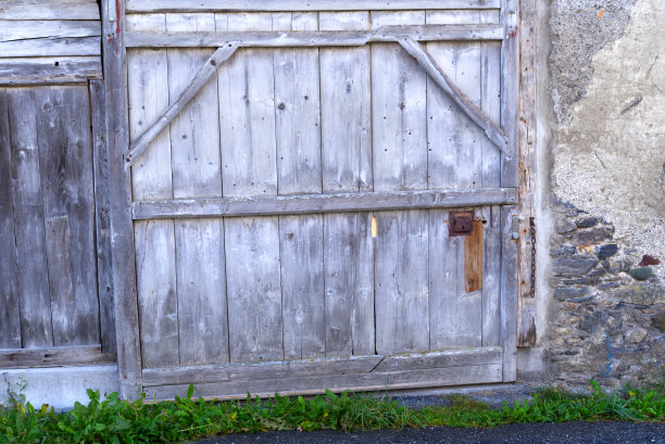 Close-up of weathered wooden gate of agriculture building at mountain village Versam, Canton Graubünden, on a sunny autumn day.图片下载