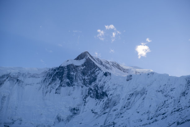白雪覆盖的山峰映衬着晴朗的天空图片下载