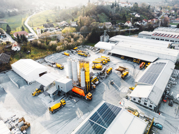 建筑公司的鸟瞰图，许多黄色卡车和重型机械停在地面上图片下载