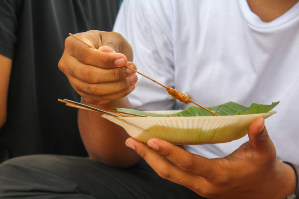 在印度尼西亚，人们手拿白色t恤在盘子上采摘。萨特是印尼的传统和特殊的食物。图片下载