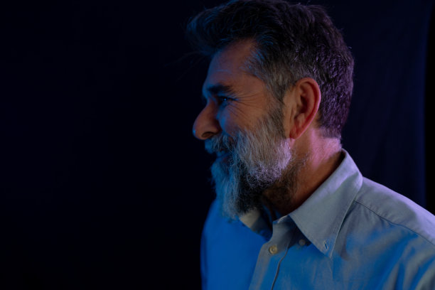 成熟帅气的模特在时尚霓虹灯下的工作室里摆姿势。穿着时髦西装的时髦男人。充满活力的颜色。明亮多彩的灯光效果。迪斯科风格。覆盖。凝胶过滤。过饱和图片下载