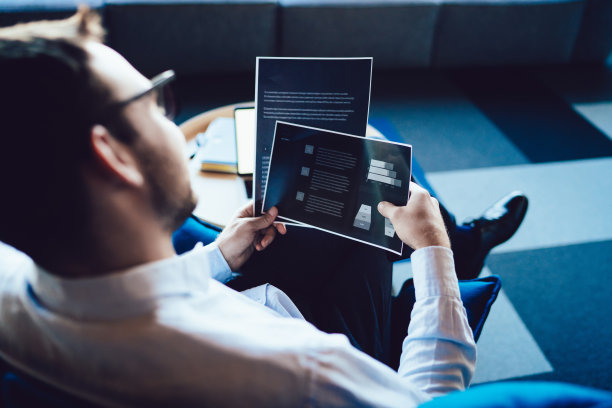 办公室职员坐在办公室的扶手椅上看文件图片下载