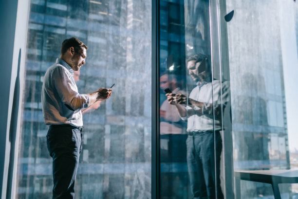 侧面视图:聪明的男性企业家在现代蜂窝设备上使用4g互联网，年轻的公司董事通过智能手机设备进行在线消息传递，并应用于通信图片下载