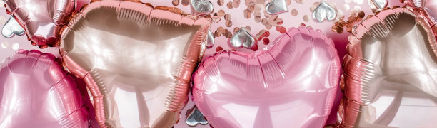 文本框架与粉红色和米色心形箔气球上的粉红色情人节背景视图。Copyspace。图片下载