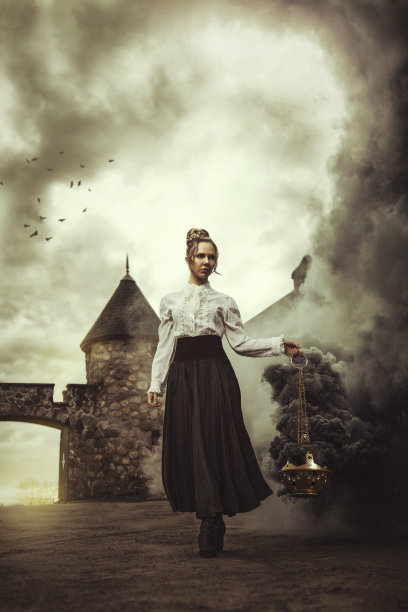 来自另一个时代的美丽的年轻金发女子，穿着长长的古典连衣裙，走在城堡前，手里拿着一个冒烟的香炉，当早晨的太阳升起时，香炉会产生巨大的烟雾漩涡图片下载