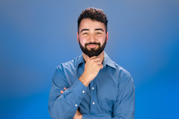 年轻人摸着下巴看着镜头图片下载