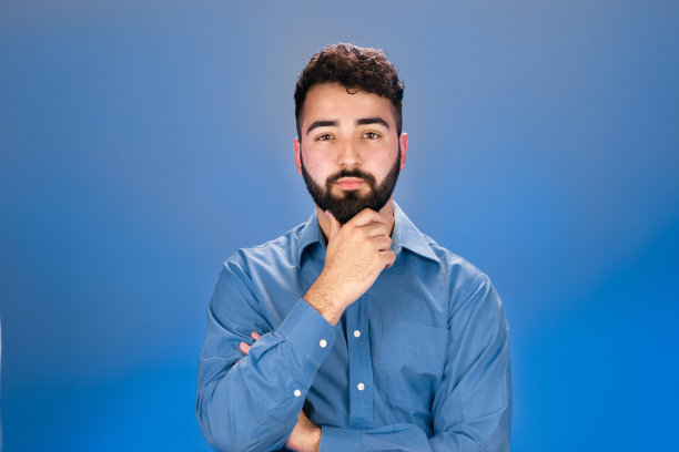 年轻人摸着下巴看着镜头图片下载