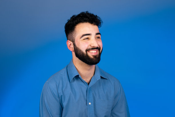 年轻的黑发男子与胡子微笑着看向别处图片下载