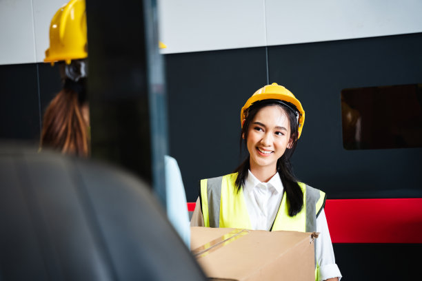 一个快乐的仓库工人的肖像在仓库或仓库，而看着相机。图片下载