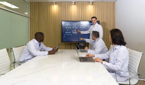 医院各科室主任出席年会。会议主持人用平板电视做报告。每个人都有自己的笔记本电脑。图片下载