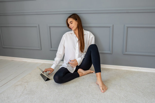 漂亮的怀孕女商人坐在办公室的地板上图片下载