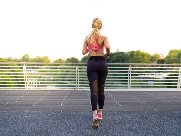 一个女孩在城市里跑步的后视图的水平照片图片下载