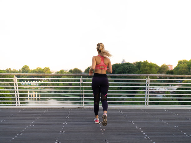 一个女孩在城市里跑步的后视图的水平照片图片下载