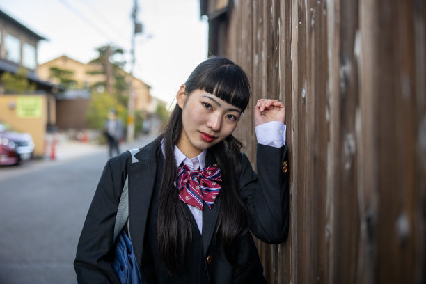 高中女孩靠在木墙上的肖像图片下载