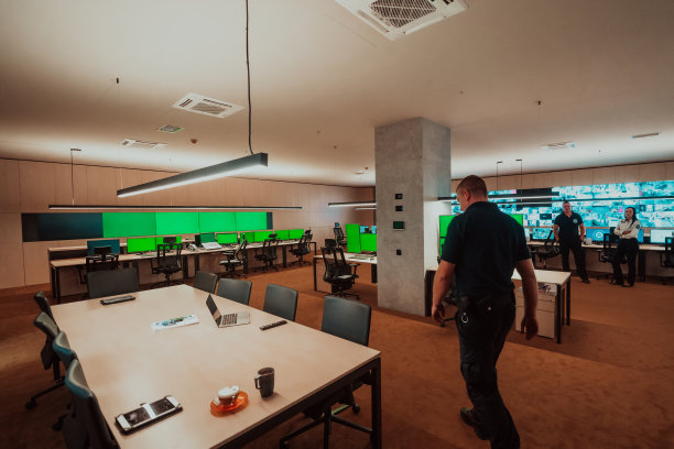 在闭路电视监控室工作的一组安全数据中心操作员，查看多个监视器，监视多个屏幕可疑活动的官员，在系统控制上工作的团队图片下载